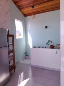 eine Küche mit weißen Wänden und einem Kühlschrank in der Unterkunft Chalé Verde Mar em São Sebastião in São Sebastião