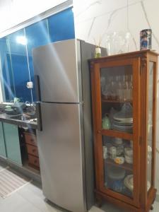 einen Kühlschrank in einer Küche neben einem Schrank in der Unterkunft Chalé Verde Mar em São Sebastião in São Sebastião