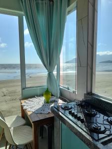 eine Küche mit Herd und Blick auf den Strand in der Unterkunft Chalé Verde Mar em São Sebastião in São Sebastião