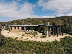 a house on the side of a hill with trees at Roaring Beach House in Nubeena