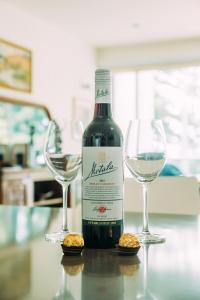 a bottle of wine and two glasses on a table at SEABREEZE at Victor Harbor in Victor Harbor