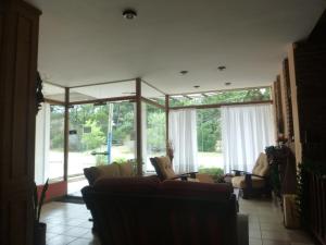 ein Wohnzimmer mit Sofas und einem großen Fenster in der Unterkunft Hosteria del Sur in Villa Gesell