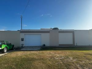 un garage con un'auto parcheggiata di fronte a un edificio di Caueira Casa Beach - Gomes & Lima a Itaporanga dʼAjuda