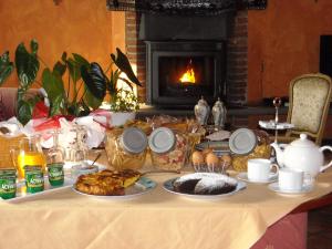 a table topped with plates of food next to a fireplace at Torre dei Frati Bed & Breakfast in Fossano
