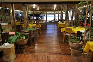 a restaurant with yellow tables and chairs and tables at White Villas Resort in Siquijor