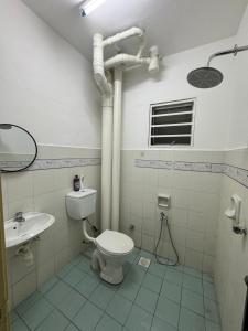 a bathroom with a toilet and a sink at Homestay Tasik Biru Kundang in Rawang