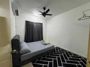 a small bedroom with a bed and a ceiling fan at Homestay Tasik Biru Kundang in Rawang