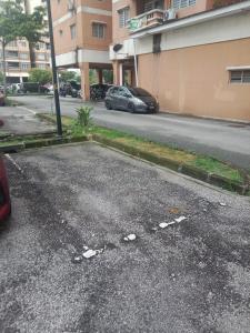 an empty street with a car parked on the road at Homestay Tasik Biru Kundang in Rawang