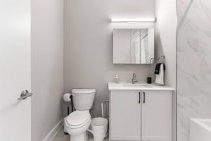 Un baño blanco con inodoro y lavabo. en Waterfront Studio - Near Fishtown and Old City, en Filadelfia 12 fotos más