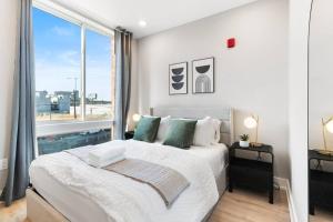 Un dormitorio con una cama grande y una ventana grande. en Waterfront Studio - Near Fishtown and Old City, en Filadelfia