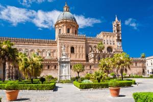 a large building with palm trees in front of it at Belle Arti in Palermo