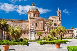 un gran edificio con palmeras delante en Belle Arti, en Palermo