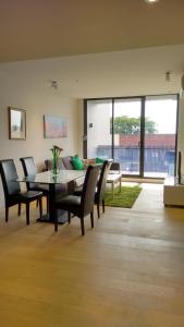 a living room with a dining room table and chairs at Camberwell Vacation Apartment in Melbourne