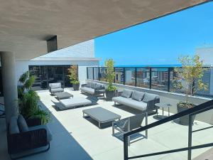 a rooftop patio with couches and tables on a building at WAY Tambáu - Pé na Areia in João Pessoa