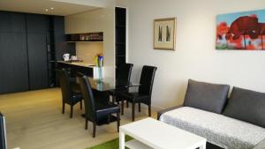 sala de estar con mesa, sillas y sofá en Camberwell Vacation Apartment, en Melbourne