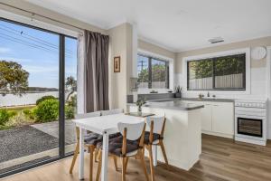 a kitchen and dining room with a table and chairs at 15 Beach St in Merimbula