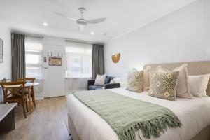 a bedroom with a large bed and a dining room at Bayscape Studio Glenelg in Glenelg
