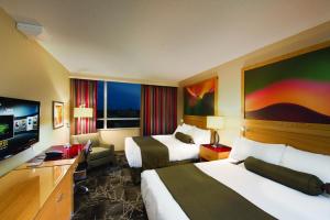 a hotel room with two beds and a flat screen tv at River Rock Casino Hotel in Richmond