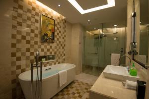 un bagno con vasca, doccia e lavandino di Panyu Hotel a Canton