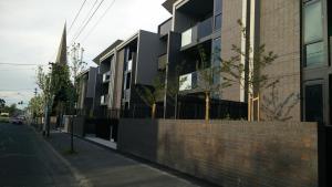 a building on the side of a street with a church at Camberwell Vacation Apartment in Melbourne