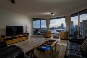 a living room with a couch and a tv at Moorings On Cavill Surfers Paradise in Gold Coast