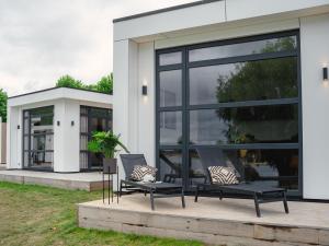 a couple of chairs sitting on a patio in front of a house at House in Arnhem with Rhine Views in Maurik