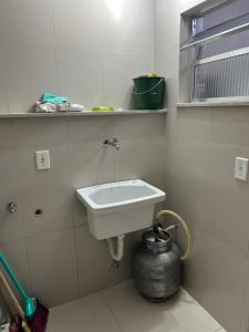 a bathroom with a white sink and a pot at Novíssimo apt 1 quarto Centro frente à Prefeitura in Nova Friburgo +37 photos