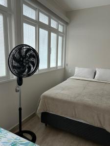 a bedroom with a fan next to a bed at Novíssimo apt 1 quarto Centro frente à Prefeitura in Nova Friburgo