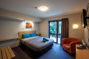 a hotel room with a bed and a chair at Ivorytowers Accommodation in Fox Glacier