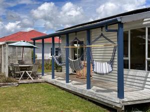 a porch with two hammocks on a house at Relaxing Raglan & the Boat House in Raglan