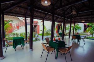 a dining room with green tables and chairs at Herbal Tea Homestay in Hoi An