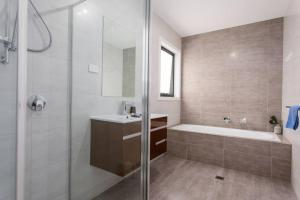 a bathroom with a tub and a sink and a shower at Bright and Chic House at Throsby with 4 Bedrooms in Harrison +7 photos