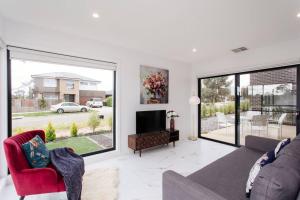 a living room with a couch and a tv at Bright and Chic House at Throsby with 4 Bedrooms in Harrison