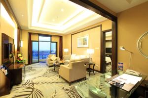 a hotel room with a living room with a room at Howard Johnson Tongfang Plaza Zhuji in Zhuji