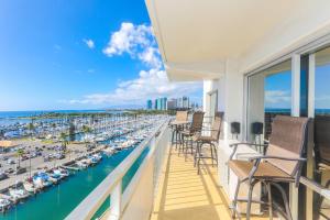a balcony with chairs and a marina with boats at Ilikai Tower 943 Yacht Harbor View 2BR in Honolulu