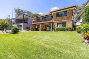 une maison avec une pelouse devant dans l'établissement 139 Government Rd - Pet Friendly, Air Con, WiFi, Water views, à Nelson Bay