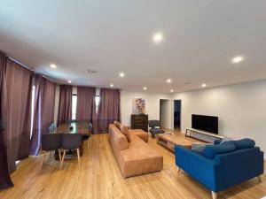 a living room with a blue couch and a tv at Brand New Delight Home at Throsby with 4 Bedrooms in Harrison