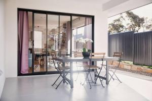 a dining room with a table and chairs at Brand New Delight Home at Throsby with 4 Bedrooms in Harrison