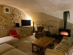 Televízia a/alebo spoločenská miestnosť v ubytovaní Mas Les Romarins, 10 min d'Uzès, piscine et grand jardin clos, jeux, nid de repos et base pour activités dans le Gard