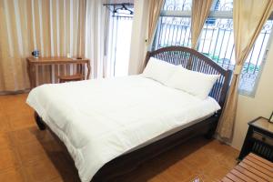 a bed sitting in a room with a window at The Grand Palace Hostel in Bangkok