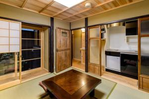 a kitchen with a wooden table and some windows at Nadeshiko Shirakawa Machiya House in Kyoto