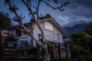 a house with a sign on the side of it at Ivorytowers Accommodation in Fox Glacier