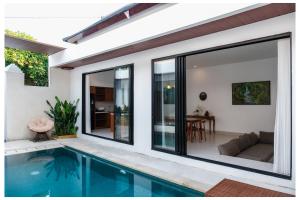 a house with a swimming pool and a living room at Gamara Villa-2BR With Pool in Ketewel