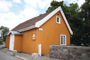 a small orange building with a stone wall at Thon Partner Hotel Horten in Horten