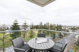 a table and chairs on a balcony with a view at Liberty 727 -Glenelg- Marina & City Views in Glenelg