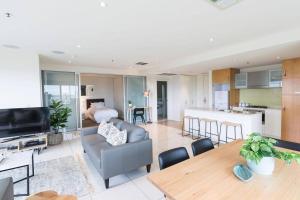 a living room with a couch and a table at Liberty 727 -Glenelg- Marina & City Views in Glenelg