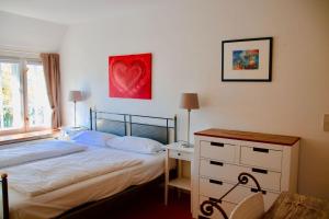 a bedroom with a bed and a red heart on the wall at Stutenhof-Wohnung-06 in Keitum