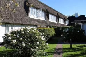 a house with a thatched roof with a pathway at Stutenhof-Wohnung-06 in Keitum