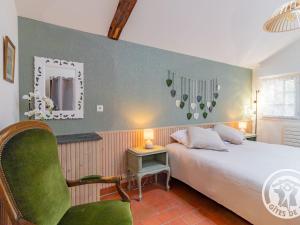 a bedroom with a bed and a chair and a mirror at Charmant gîte près d'Angers avec extérieur privé - FR-1-622-93 in Andard