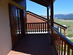 a balcony of a cabin with a view of the mountains at Chalet spacieux 3 pièces avec parking et jardin - FR-1-593-122 in Les Angles
